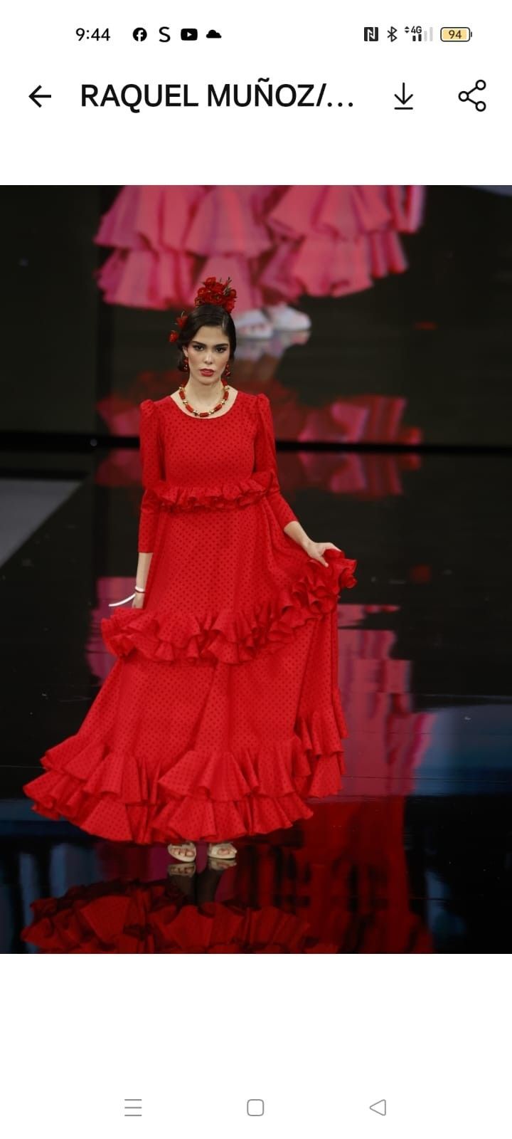Modelo con un vestido rojo con volantes en una pasarela, con un espectacular fondo rosa.