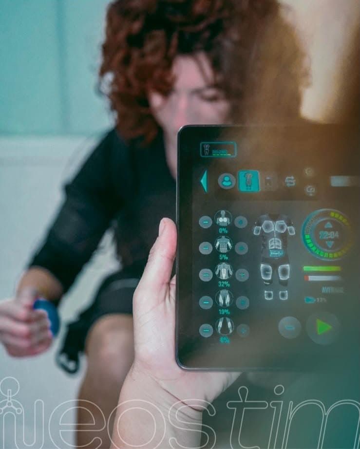 Persona haciendo ejercicio en bicicleta con una pantalla digital transparente de fitness en primer plano.