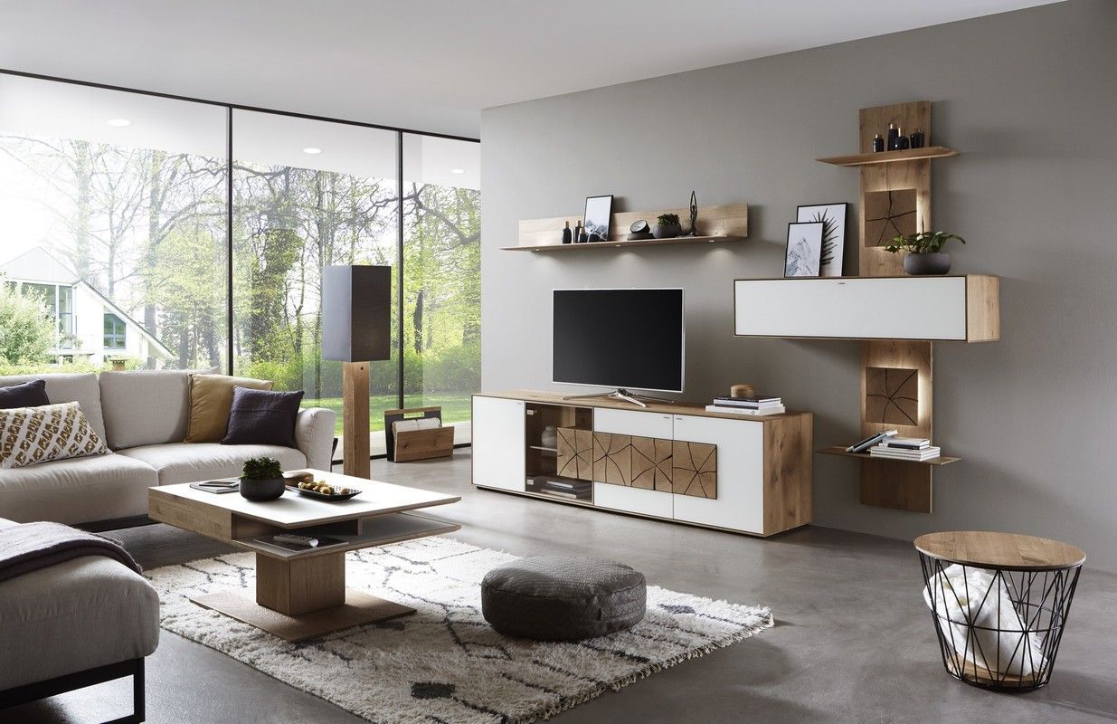 Wohnzimmer mit Wohnwand, die weißen Möbel haben Holzelemente und Beleuchtung eingearbeitet