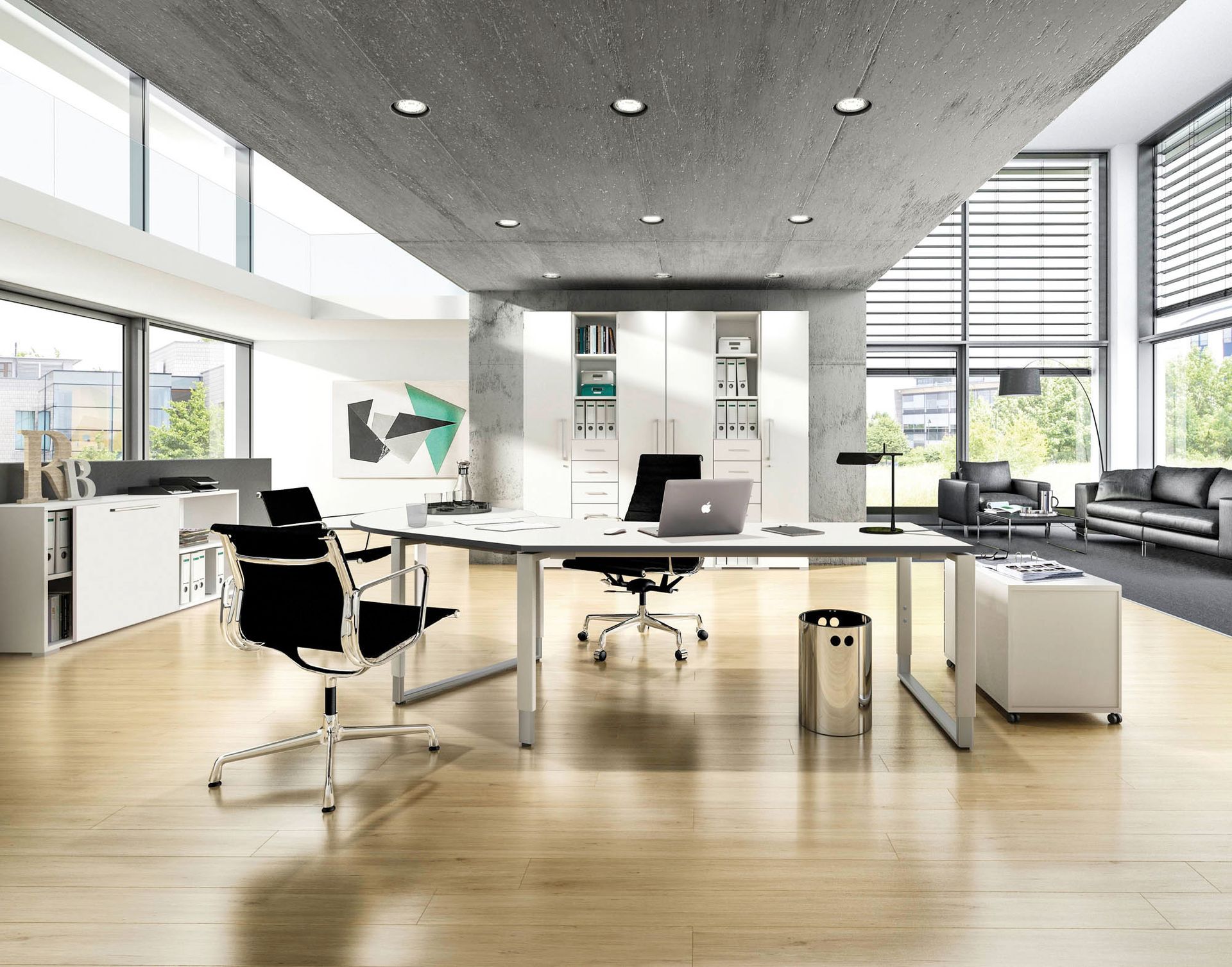 Abgerundeter Schreibtisch mit drei Stühlen daran und einem Laptop darauf. Im Hintergrund steht ein weißer Aktenschrank.