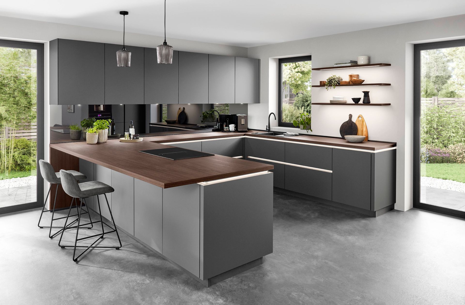 Moderne grifflose Küche in Anthrazit, die Arbeitsplatte ist in dunklem Holz gehalten und es gibt eingebaute Lichtakzente