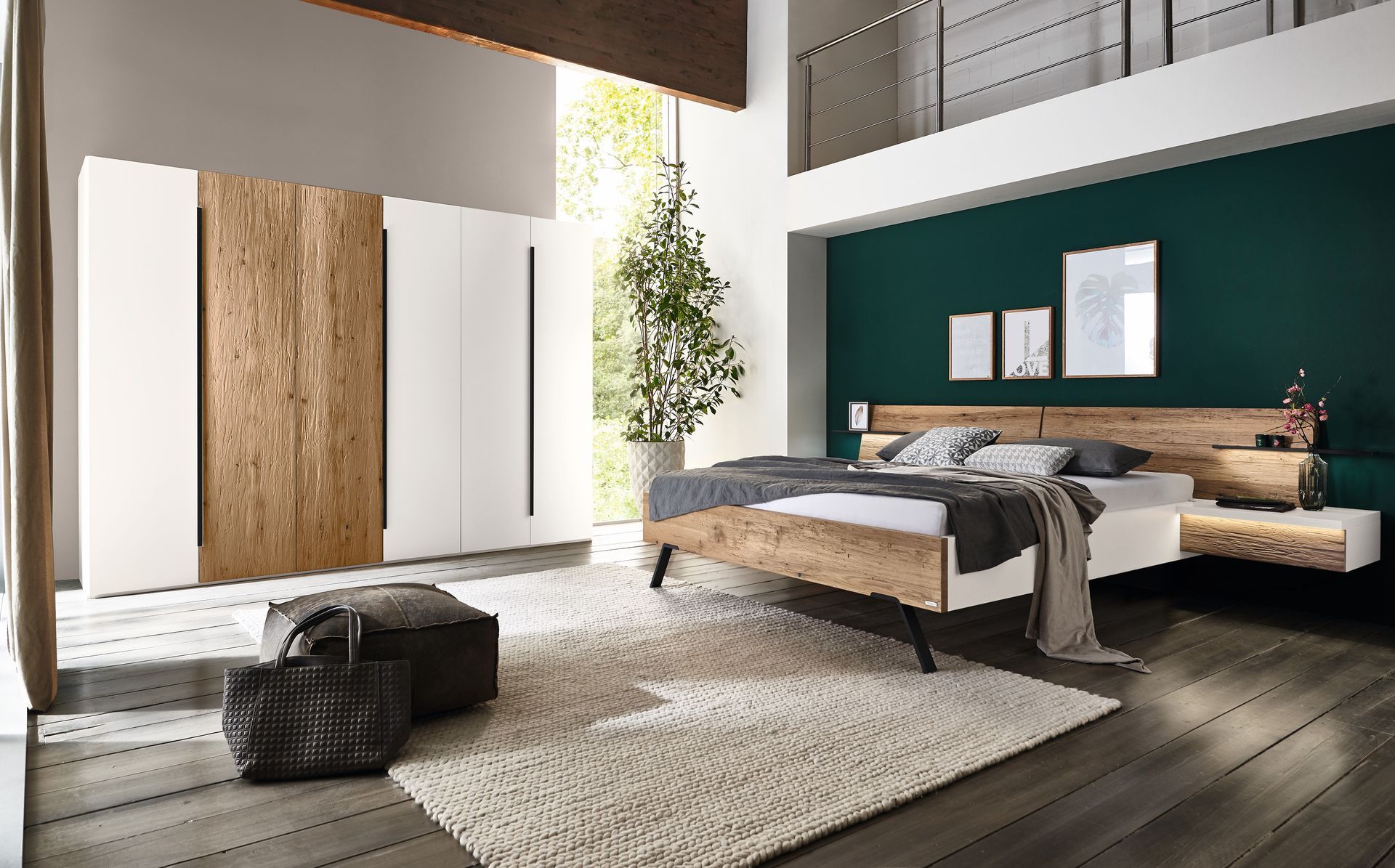 Hohes Schlafzimmer mit einem Holz-Doppelbett und einer Weiß-Hölzernen-Schrankwand