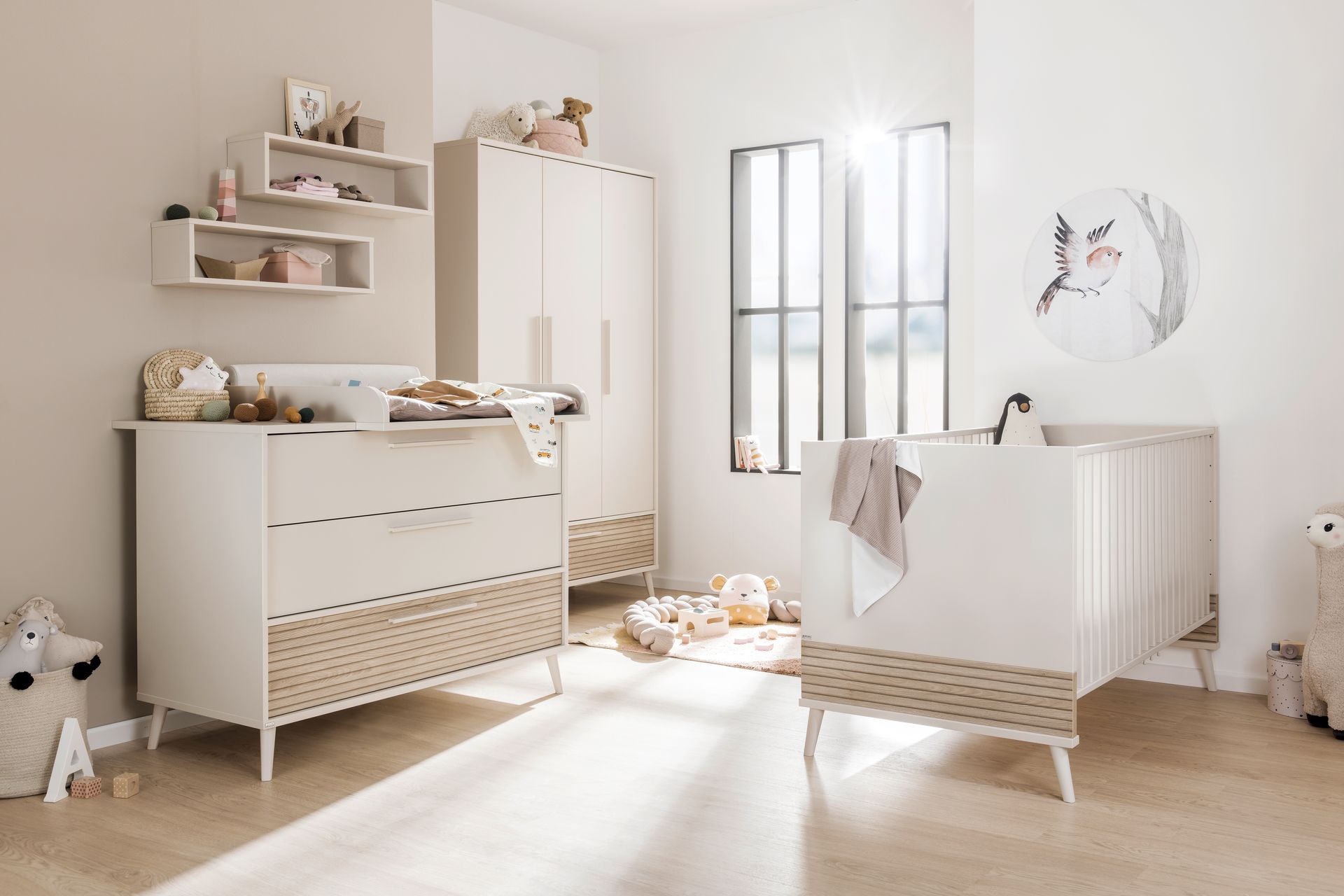 Modernes Babyzimmer in beige und mit hellen Holzakzenten sowie süßem Spielzeug