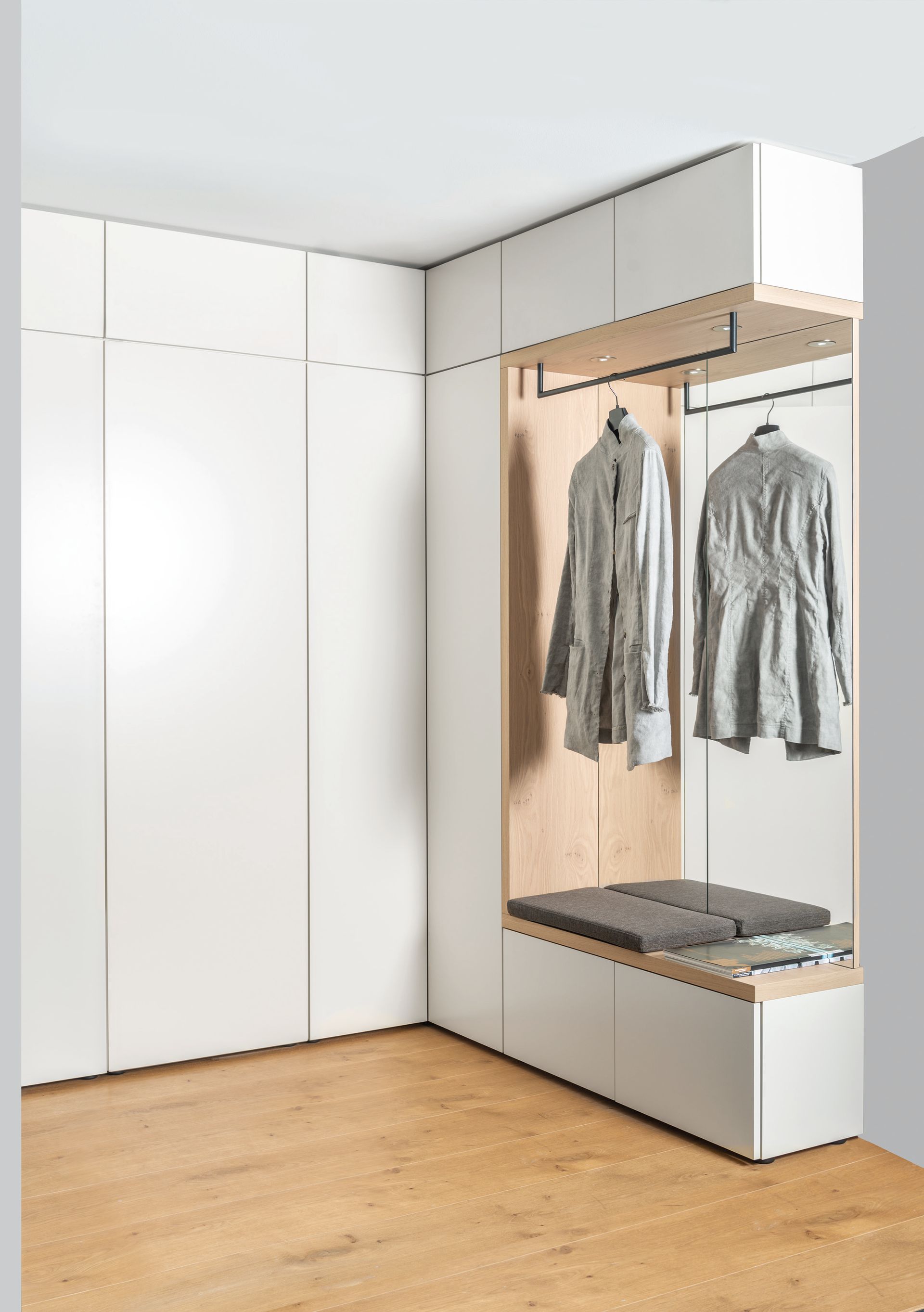 Weißer glatter Flurschrank mit Aussparung für Jacken und eine Sitzfläche