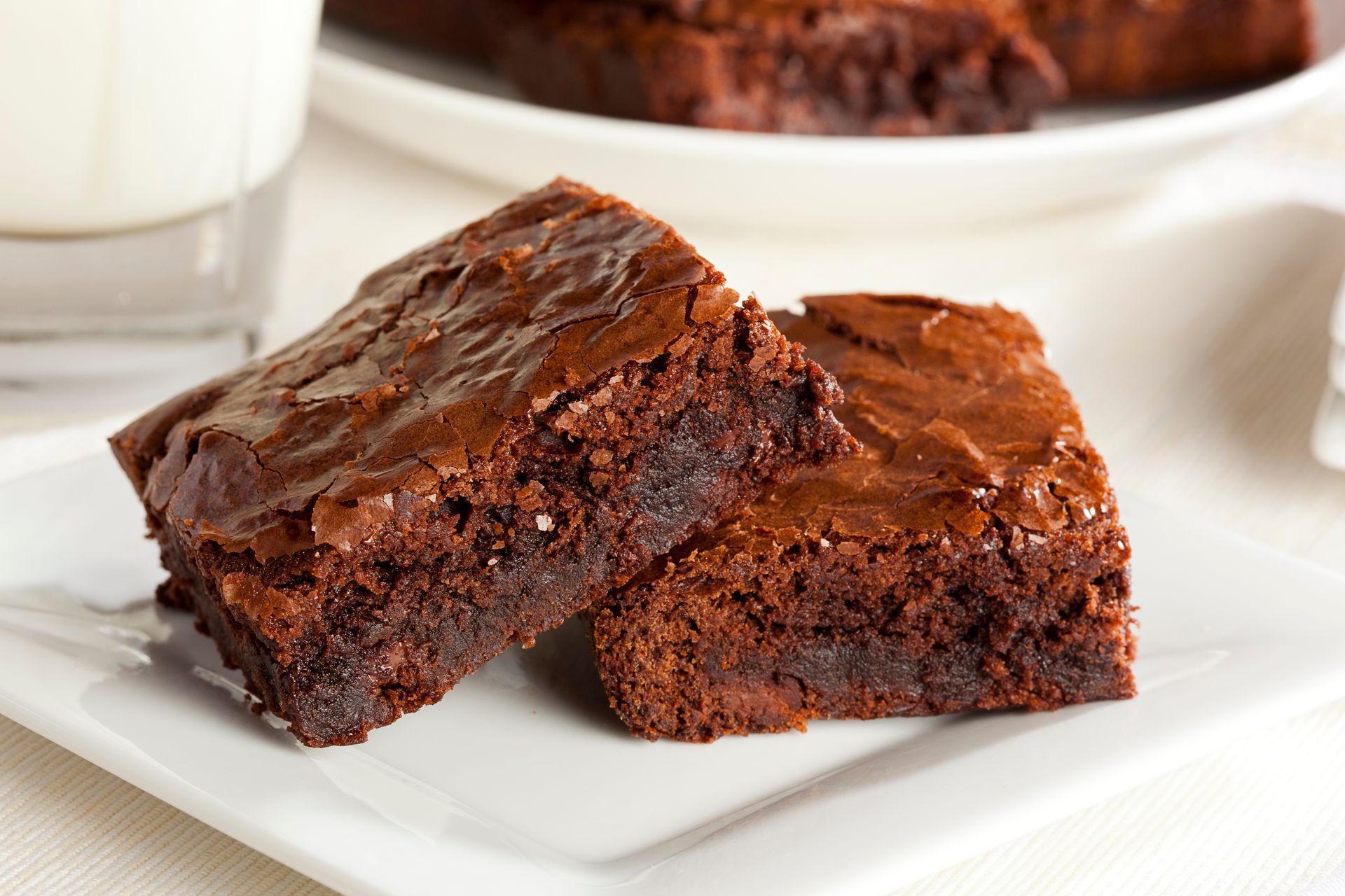 Deux brownies au chocolat sur une assiette blanche, l'un sur l'autre