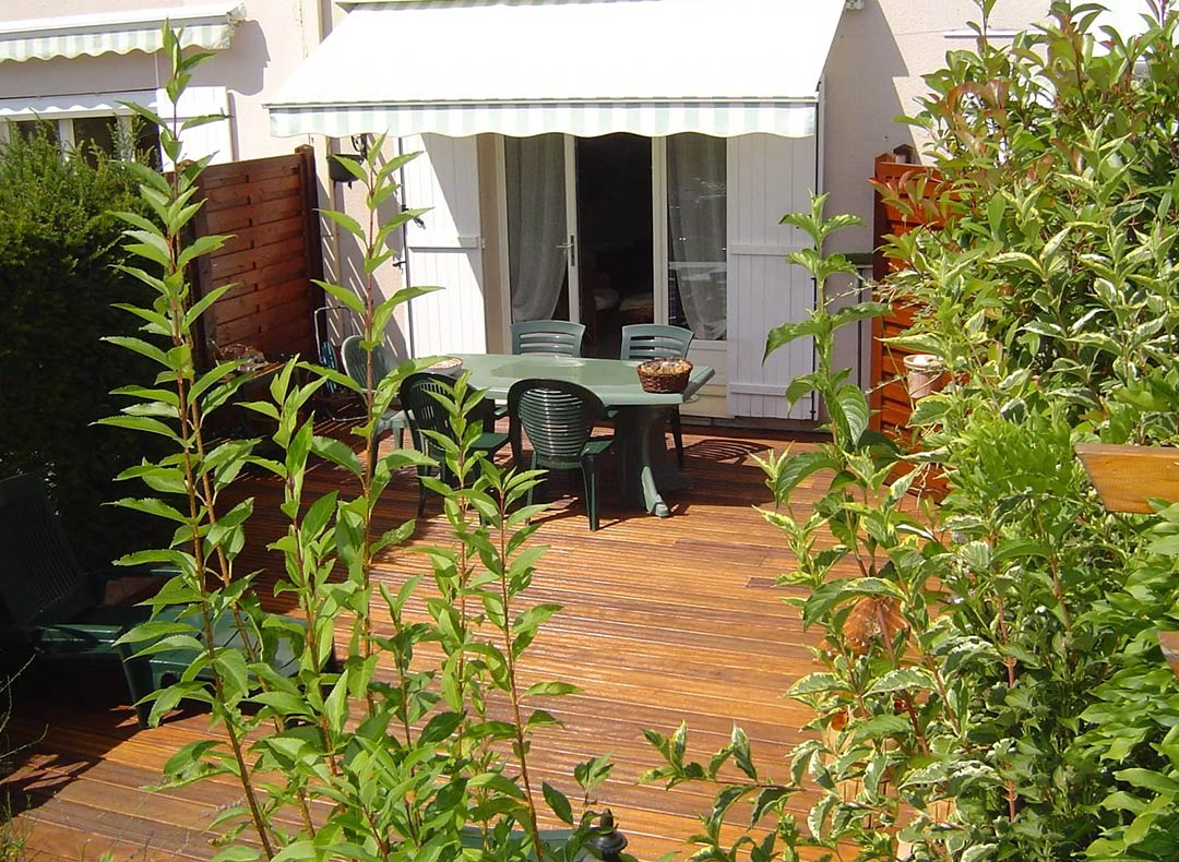 Arbuste dans une cour intérieure avec terrasse en bois