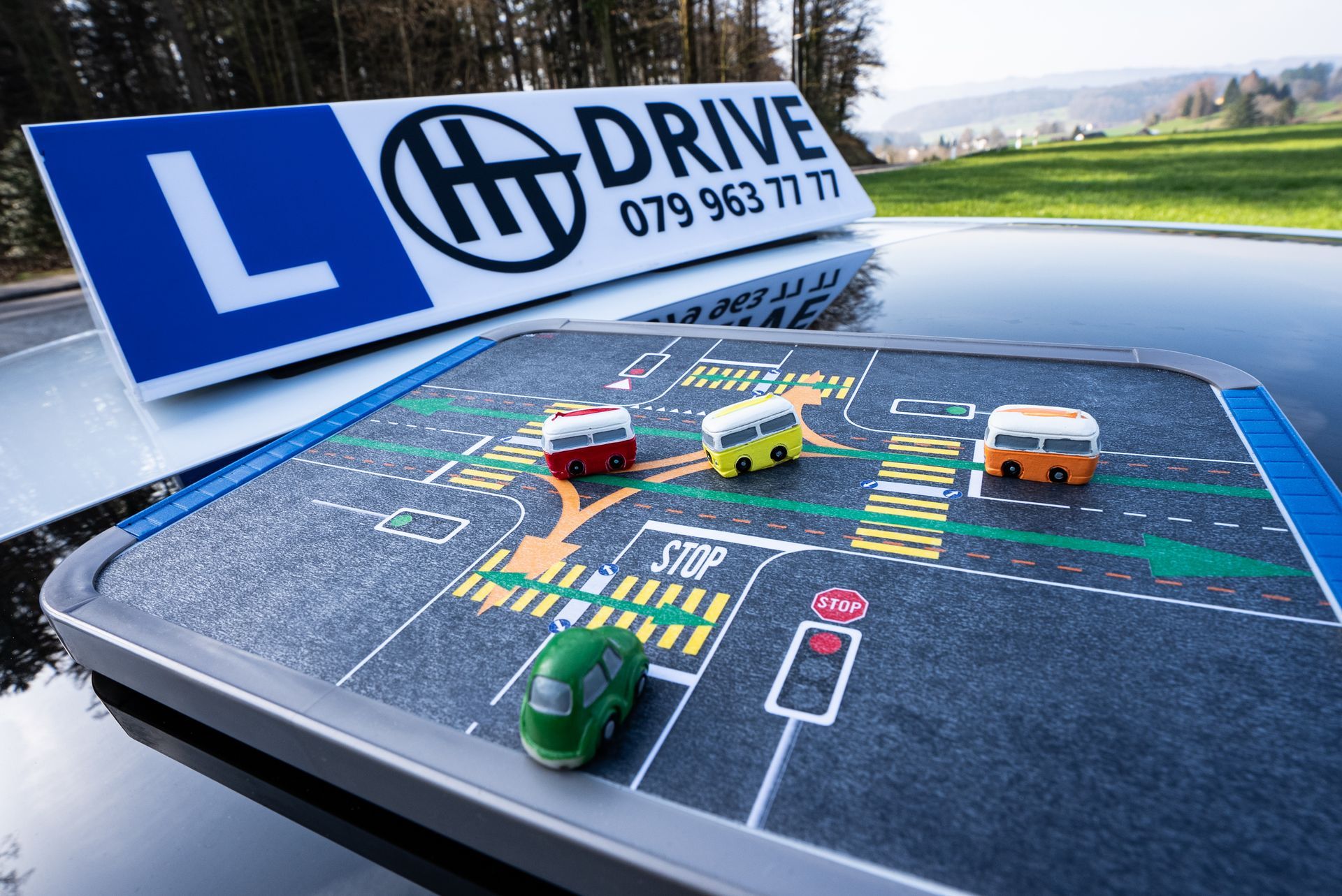 Ein Fahrer hält ein Lenkrad und absolviert eine Fahrprüfung. Ein Prüfer hält ein Klemmbrett im Auto.