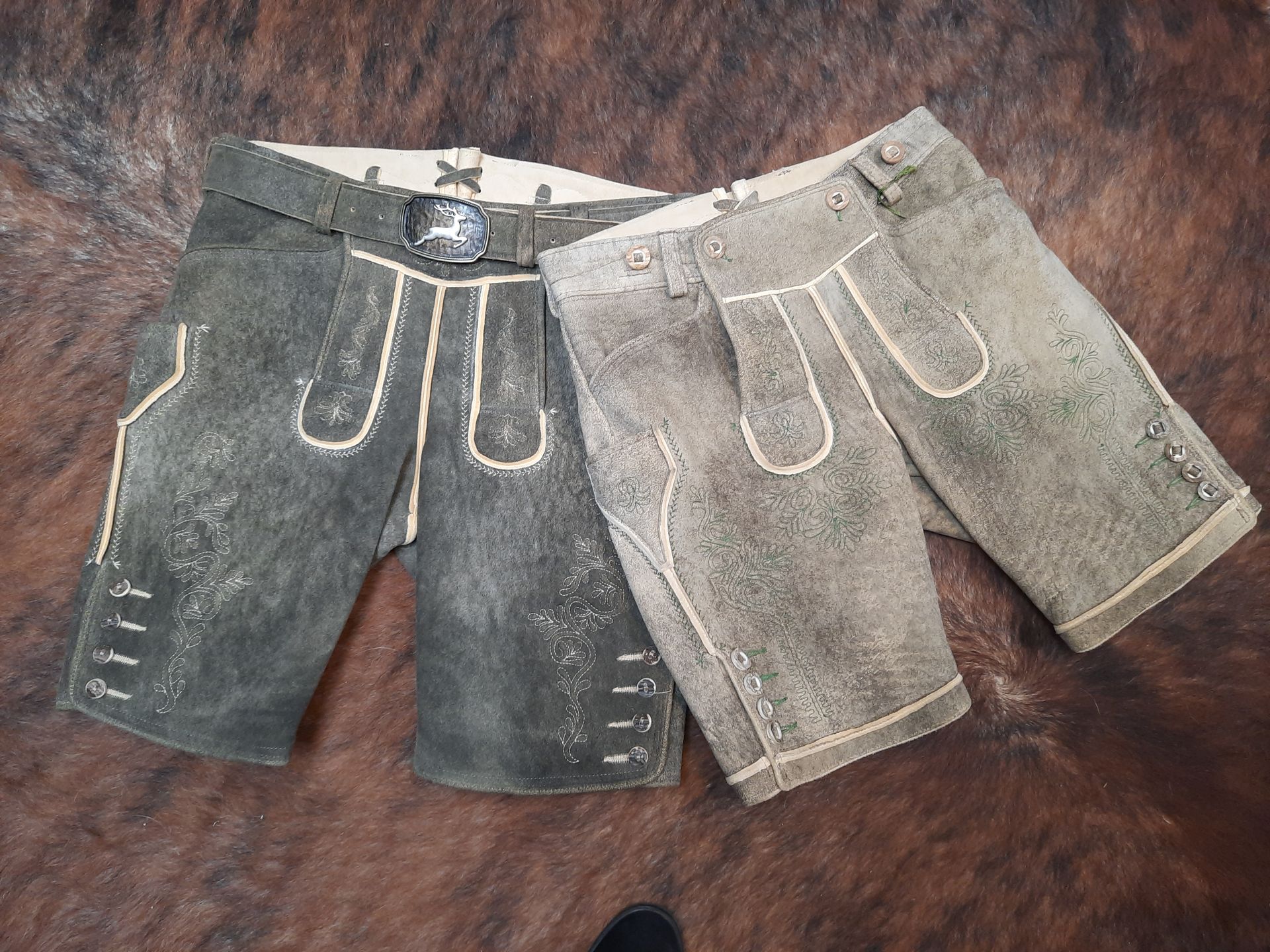 Drei Paar Shorts liegen übereinander auf einer braunen Fläche.