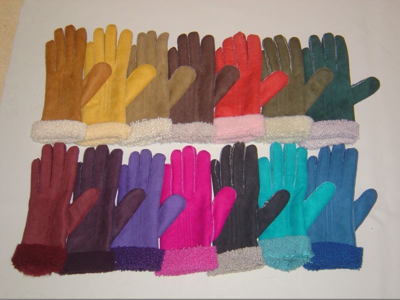 Viele verschiedenfarbige Handschuhe sind auf einer weißen Fläche aufgereiht