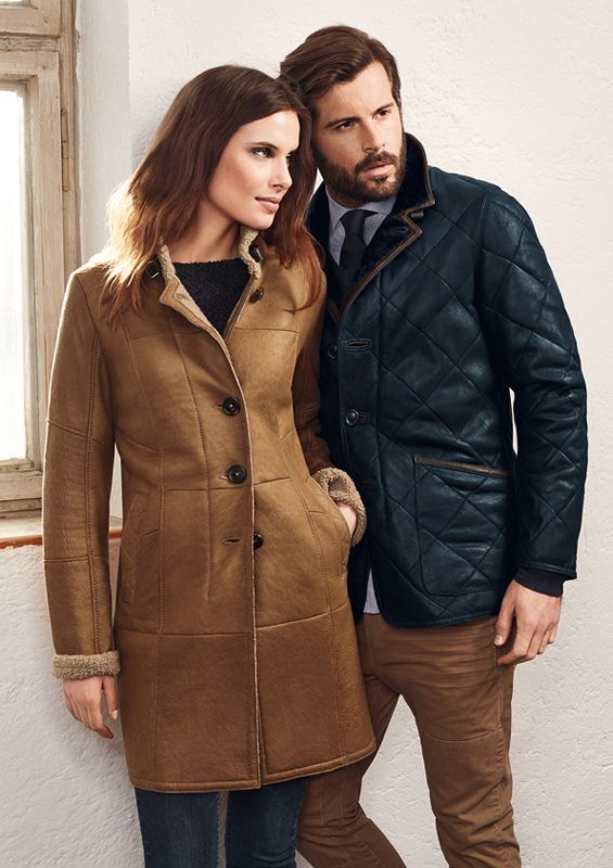 Ein Mann und eine Frau stehen in Mänteln nebeneinander.