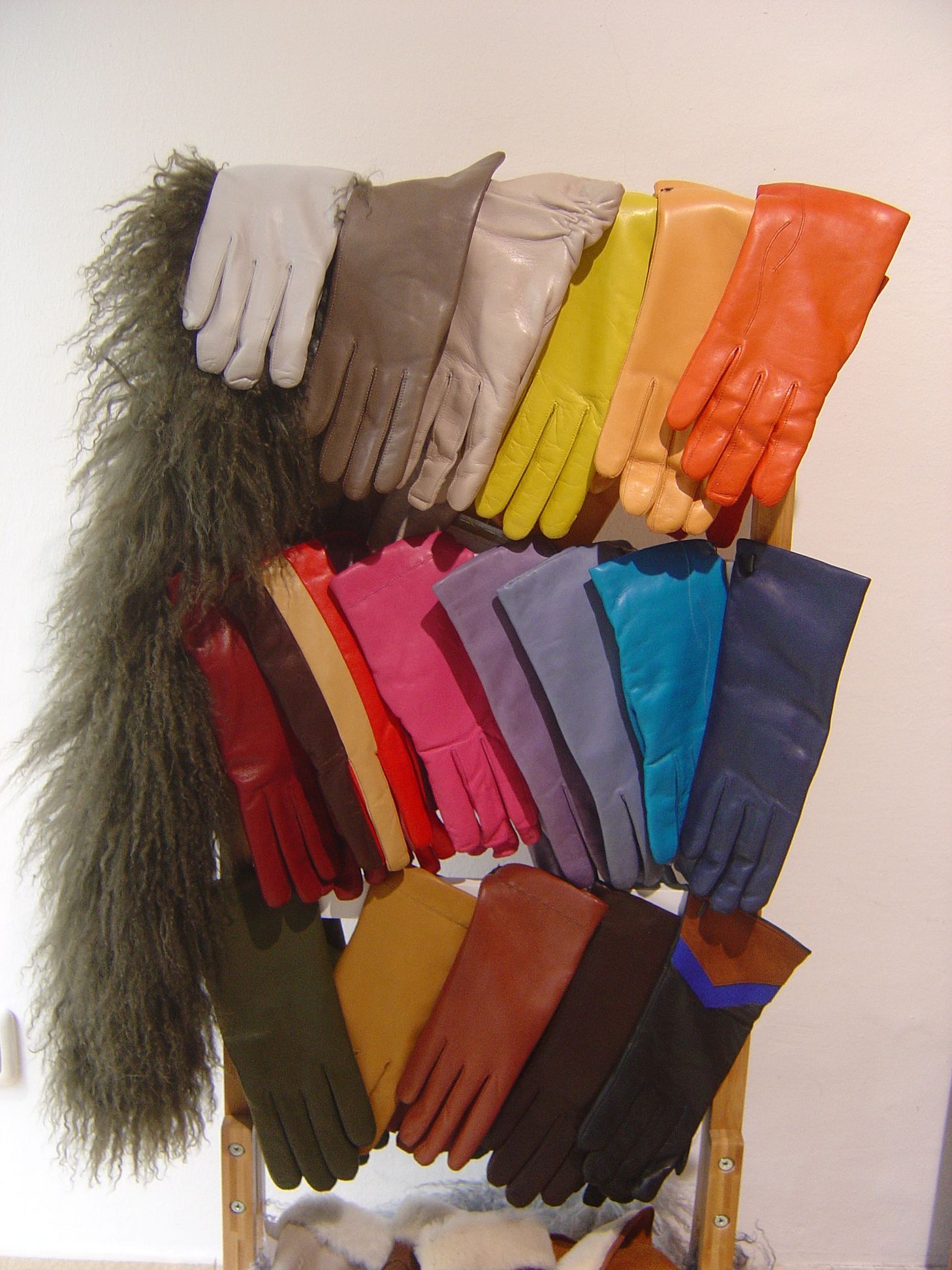 Viele verschiedenfarbige Handschuhe werden auf einem Ständer präsentiert