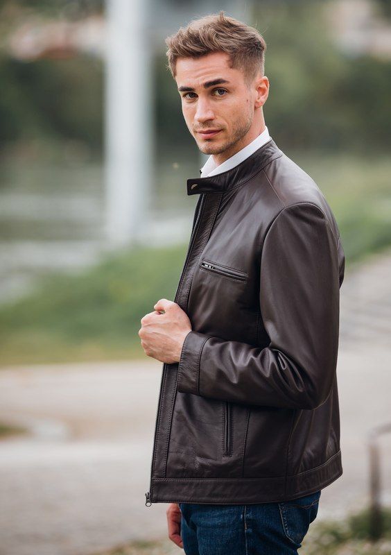 Ein Mann trägt eine braune Lederjacke und Jeans.