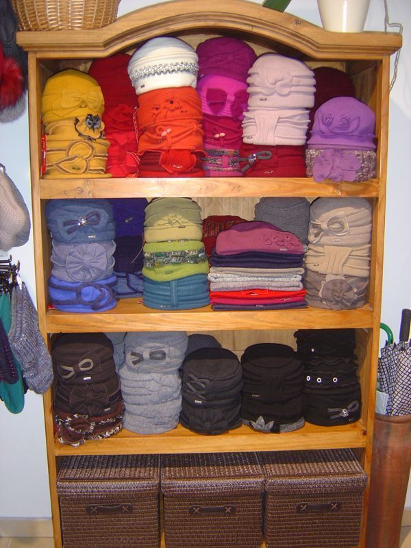 Ein Regal voller Mützen und Schals, darunter einer mit der Aufschrift „Adidas“