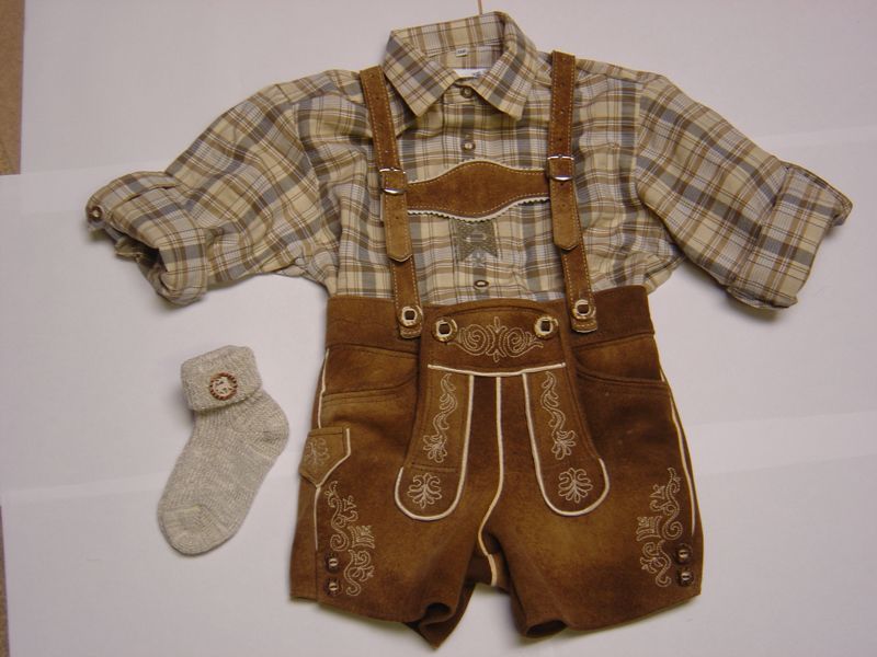 Ein Paar Socken liegt neben einem karierten Hemd und braunen Shorts