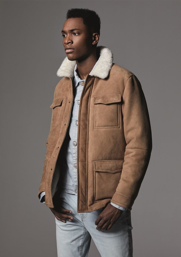 Ein Mann trägt eine braune Jacke mit Pelzkragen.