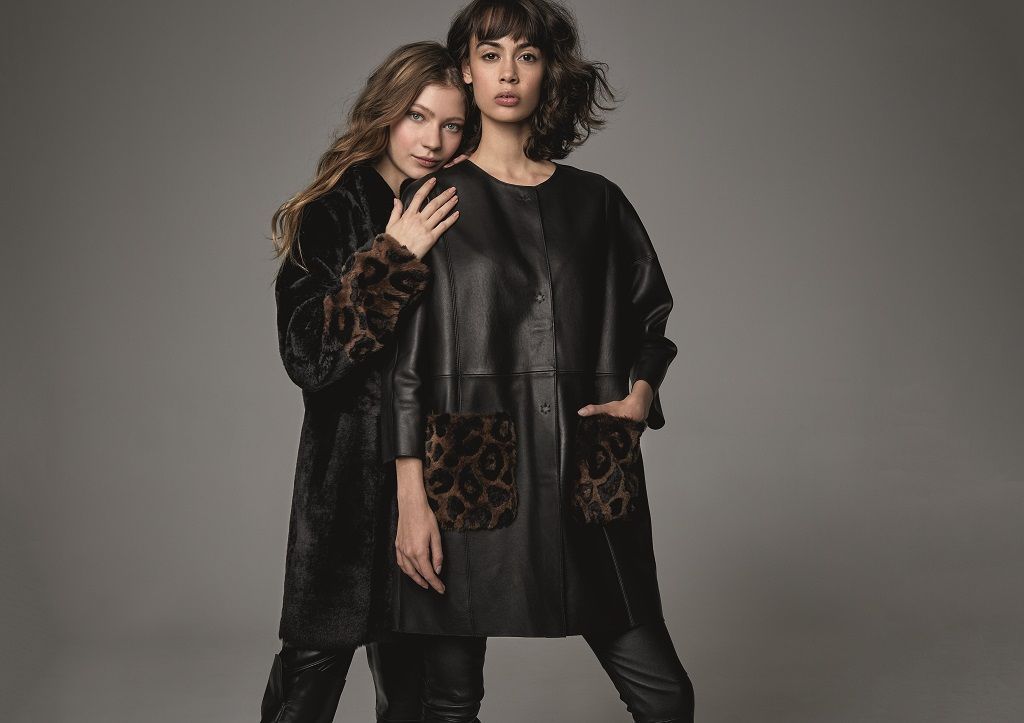 Zwei Frauen in Pelzmänteln stehen nebeneinander.