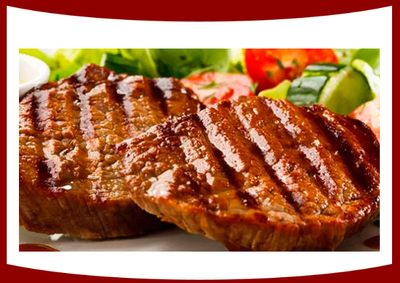 Un primer plano de un filete a la parrilla en un plato con verduras.