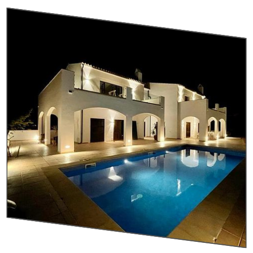 Una gran casa blanca con una piscina delante de ella.