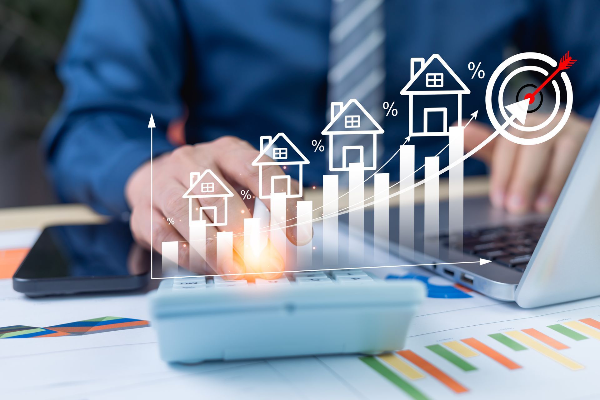 Ein Mann benutzt einen Laptop mit einem Taschenrechner und einem Mobiltelefon.