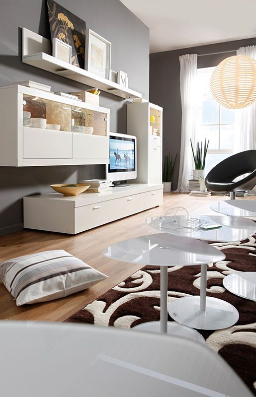 Werbefotografie - Ein Wohnzimmer mit weißen Möbeln und einem Fernseher an der Wand