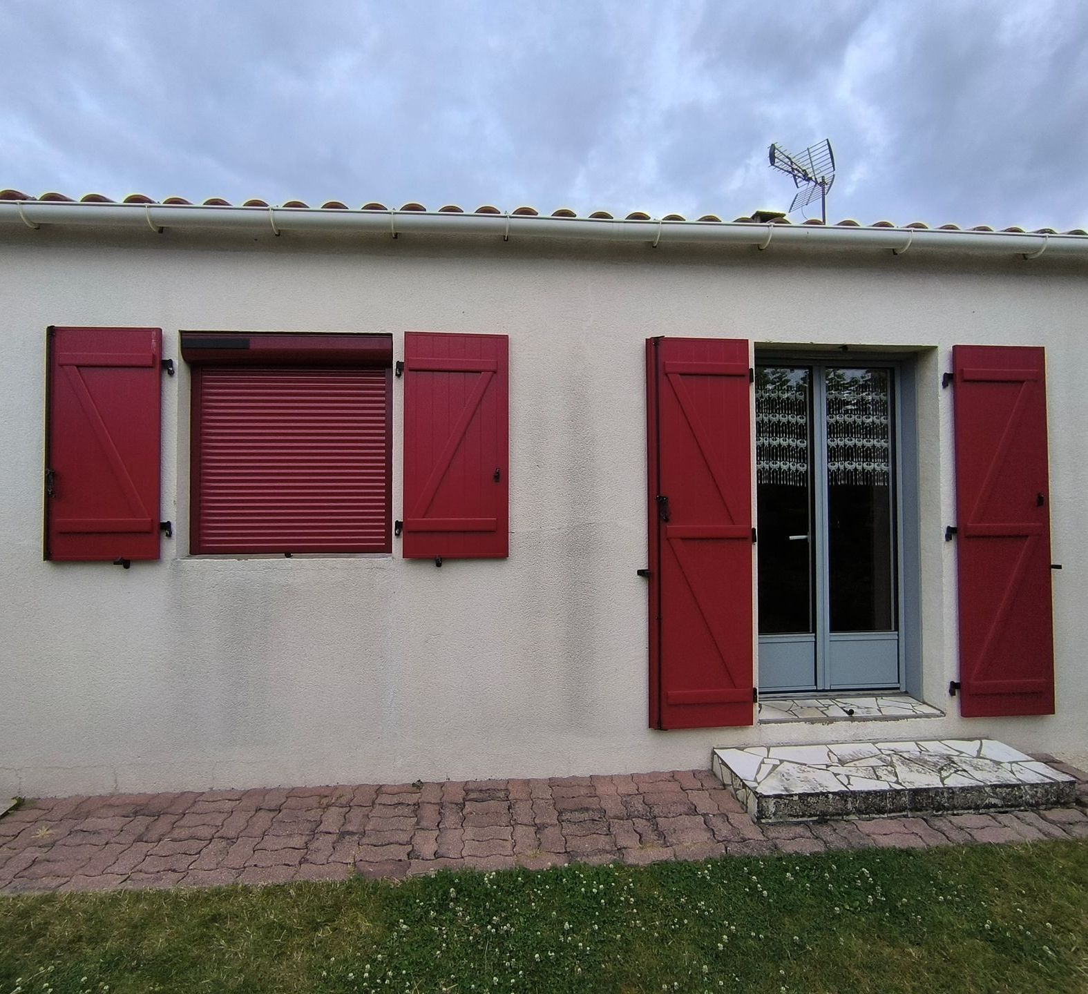 Une maison avec de la menuiserie extérieure rouge