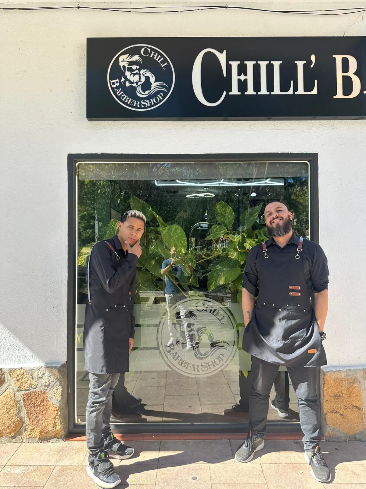 Dos personas están afuera de una barbería,