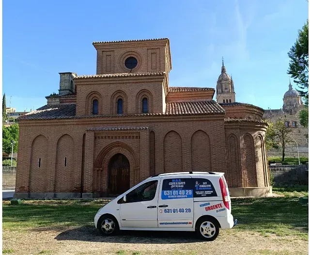 Una camioneta blanca está estacionada frente a un edificio de ladrillo.