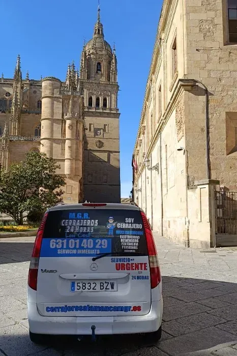Una camioneta blanca está estacionada frente a un gran edificio.