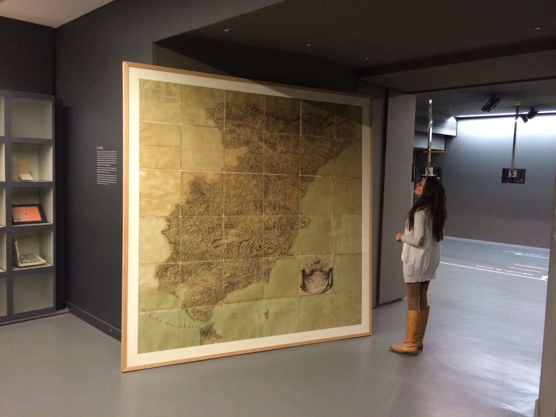 Una mujer está delante de un gran mapa de España.