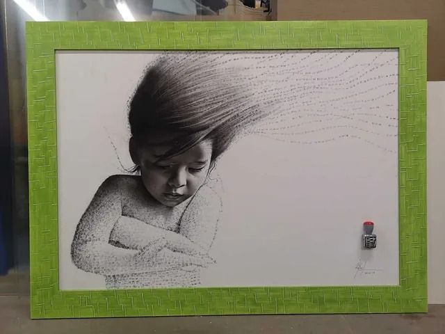 Un dibujo en blanco y negro de un bebé en un marco verde.