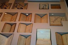 Un montón de libros están colocados en un estante en una pared.
