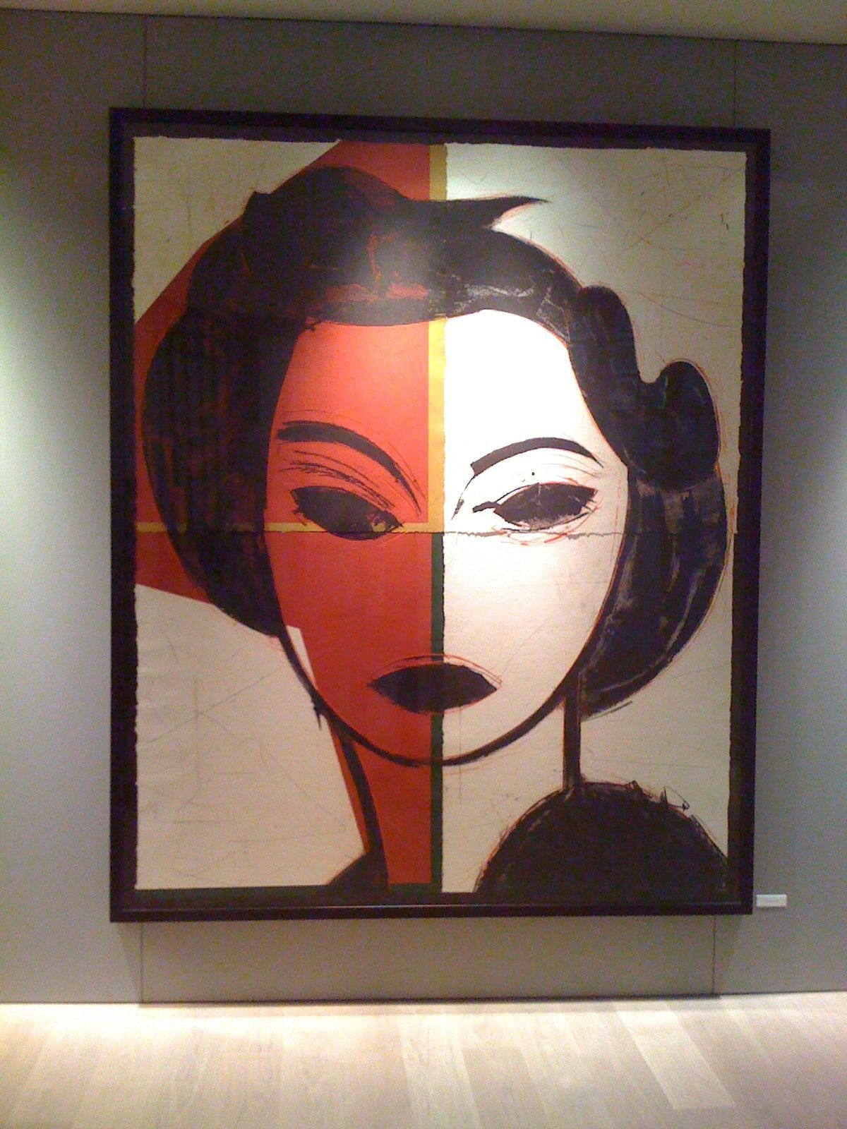 Una pintura del rostro de una mujer con mitad rojo y mitad blanco.