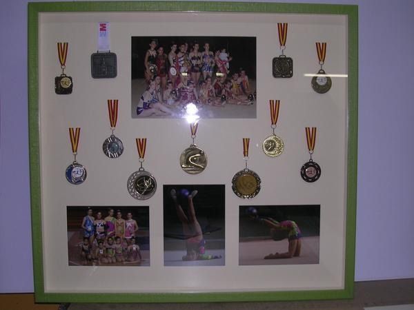 Una exhibición enmarcada de medallas y una fotografía de un grupo de personas.