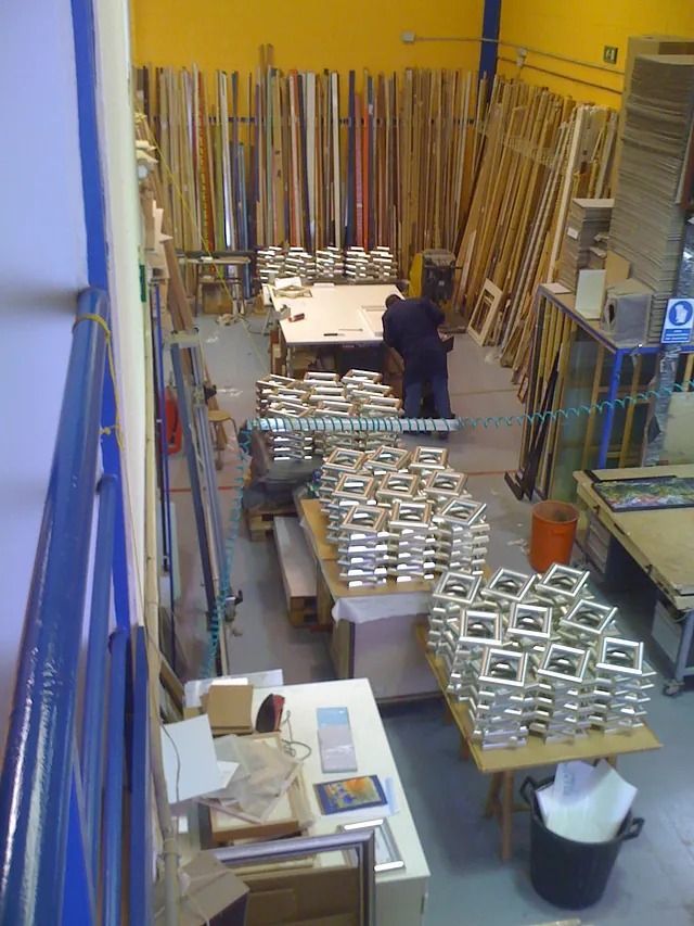 Un hombre está trabajando en un almacén lleno de madera.