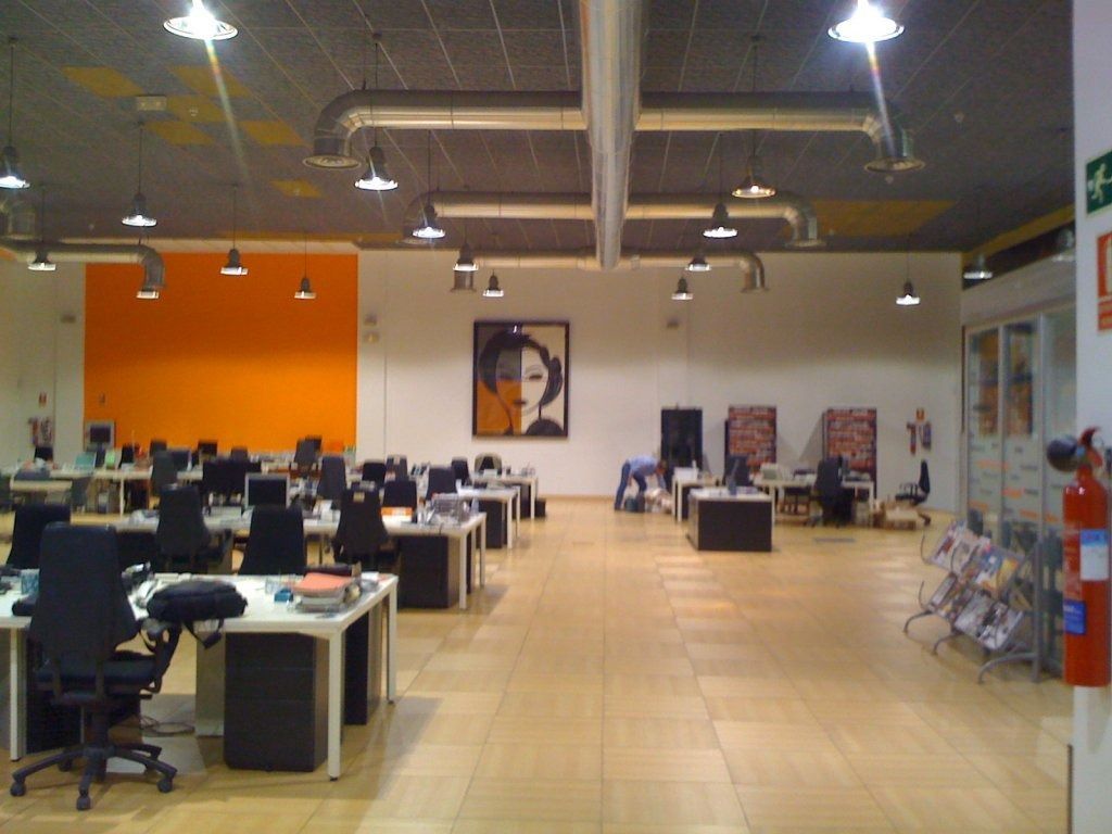 Una oficina grande con muchos escritorios y sillas.