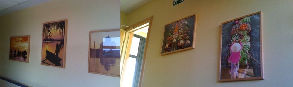 Un pasillo con cuadros en la pared y una puerta.