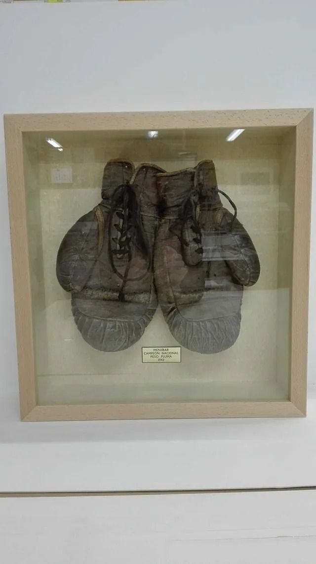 Un par de guantes de boxeo se exhiben en una vitrina.