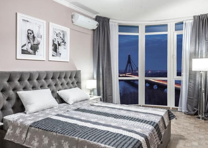 Ein Schlafzimmer mit zwei Betten und einem großen Fenster mit Blick auf eine Brücke.