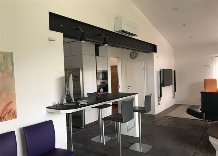 Ein Wartezimmer mit lila Stühlen und einer Uhr an der Wand