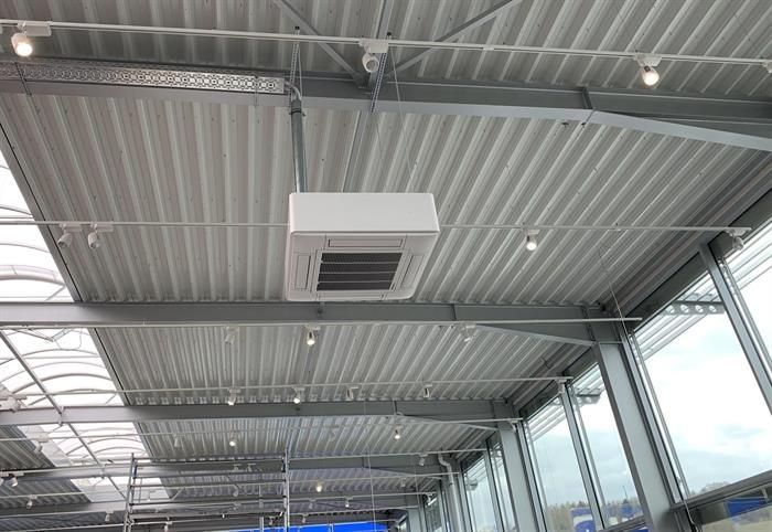 Die Decke eines Gebäudes mit vielen Fenstern und einem daran hängenden Deckenventilator.