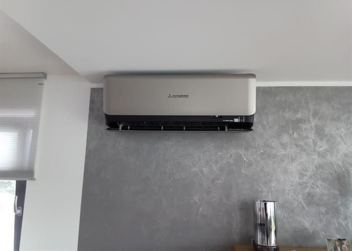 In einem Wohnzimmer hängt eine Klimaanlage von Mitsubishi von der Decke.