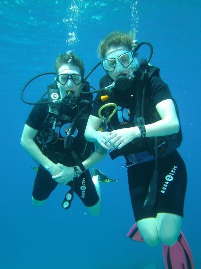 Zwei Personen tauchen und einer von ihnen trägt ein Taucherhemd