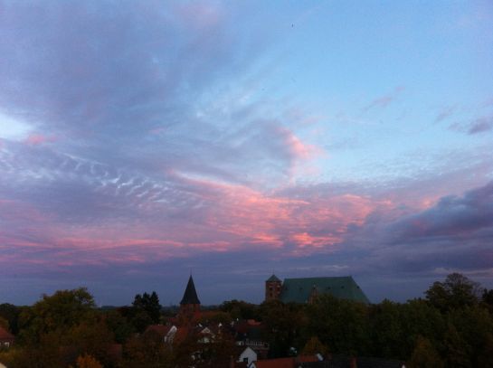 Ein bewölkter Himmel mit ein paar Gebäuden im Vordergrund