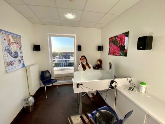 Eine Frau sitzt an einem Schreibtisch in einem Zimmer