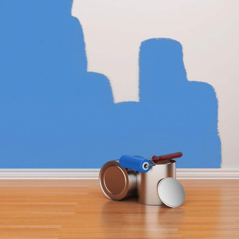AST-Trans GmbH - Eine Dose Farbe steht auf einem Holzboden vor einer blauen Wand
