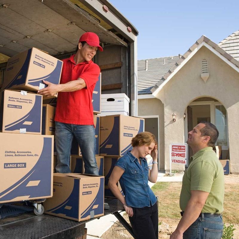 AST-Trans GmbH - Ein Mann im roten Hemd lädt Kisten in einen großen Kastenwagen