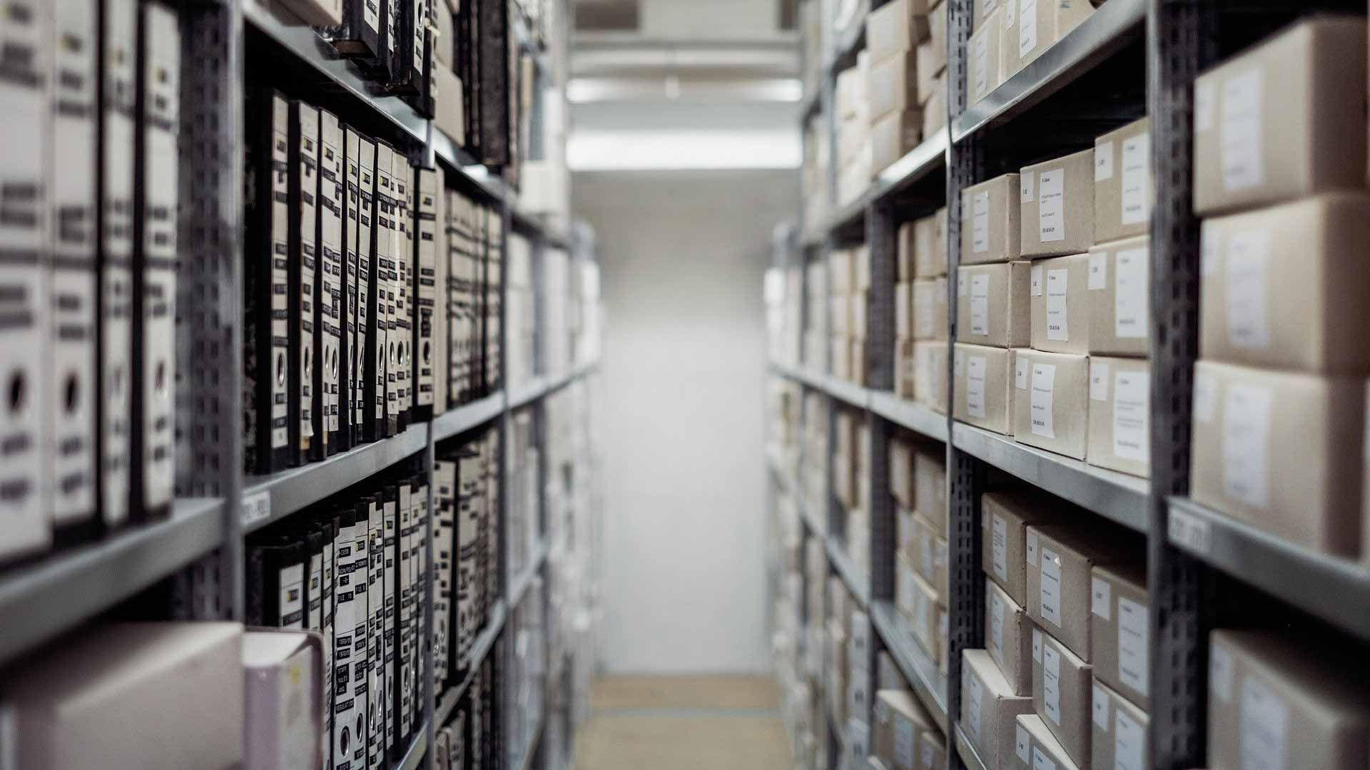 AST-Trans GmbH - Ein Lagerhaus voller Regale voller Kisten und Ordner.