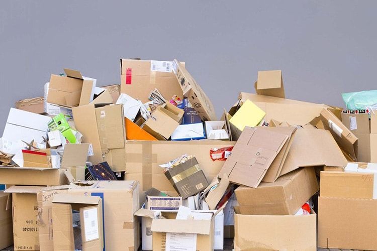 AST-Trans GmbH - Ein Stapel Kartons auf grauem Hintergrund