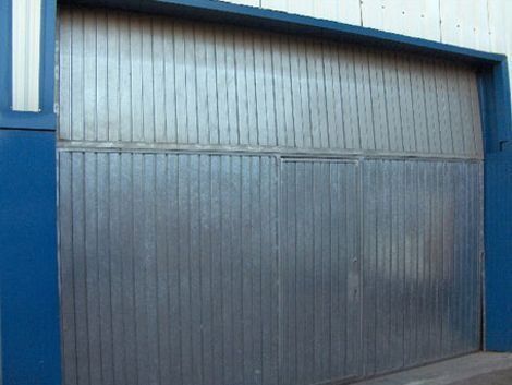 Una gran puerta de garaje de metal con un borde azul.