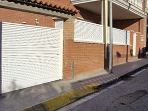 Un edificio de ladrillo con persianas blancas en el lateral.